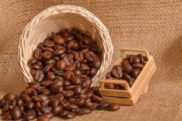 Coffee beans and cinnamon on a background of burlap. Roasted coffee beans background close up. Coffee beans pile from top with copy space for text. Seasoning. Spice. Cinnamon. Badian. Coffee house.