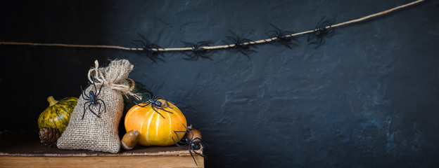 Halloween holiday background with pumpkin, lantern, spiders, old books, black witchhat
