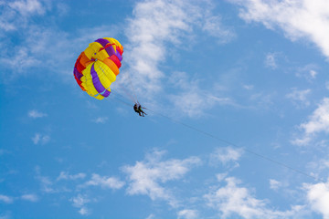 Fototapeta na wymiar Man flying on a round bright parashute