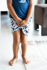 Boy with hands holding his crotch in toilet