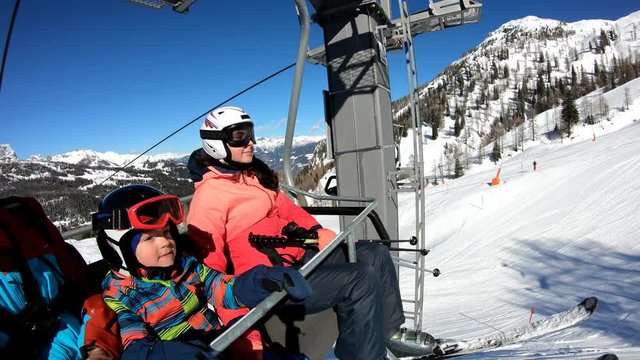 Family on chairlift.
The boy and his parents rest on their way to the slopes. Stabilized footage.
