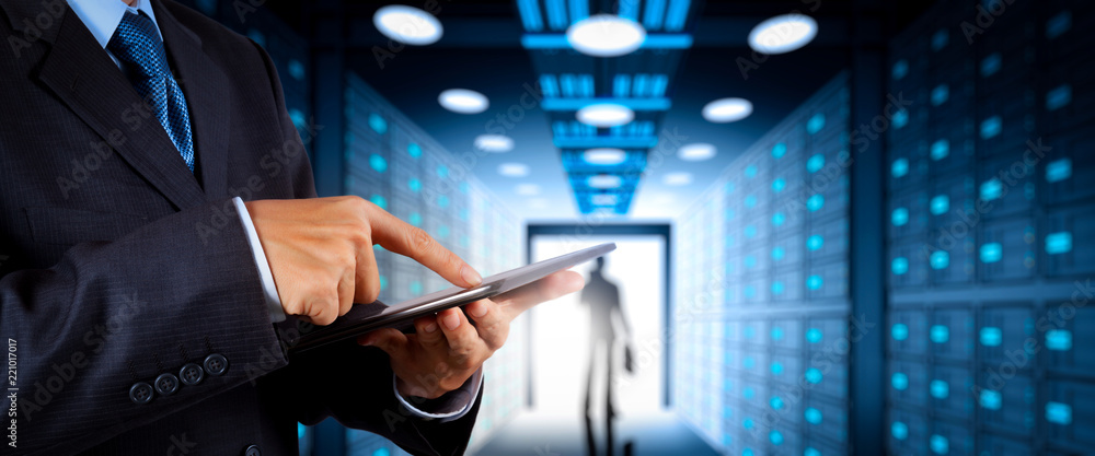 Aufkleber businessman working with vr wide blank screen computer on server room in background.