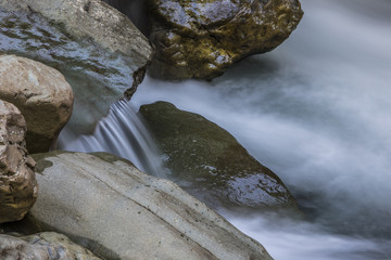 Fototapeta premium A long exposure of a river flowing along rocks
