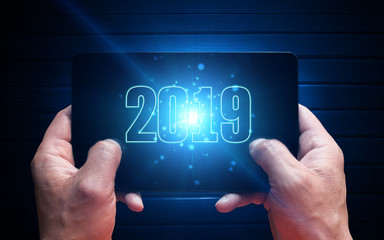 Obraz premium Computer tablet in male hands close-up, top view. Neon light, magic