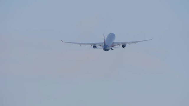 Big passenger airliner gains height after take off and flies away