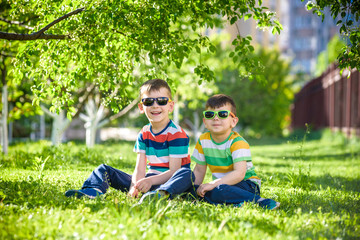 Happy summer holidays. Two happy children on a green lawn at a summer park.