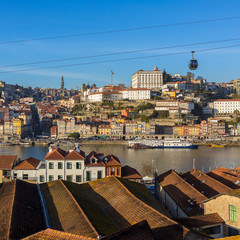 Fototapeta na wymiar Porto, Portugal - Januaryt 19, 2018: View of the historic city of Porto with famous bridge Ponte dom Luis, cable cars and boats on Douro river, Portugal