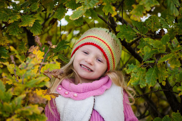 adorable girl in scarf in autumn forest