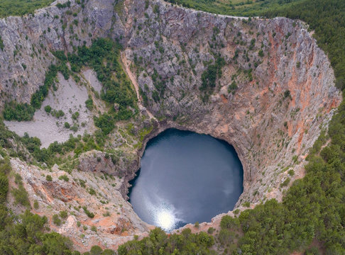 Red Lake (Croatian: Crveno jezero) is a collapse doline (collapse sinkhole) containing a karst lake close to Imotski, Croatia. It is 530 metres deep, thus it is the largest collapse doline in Europe.