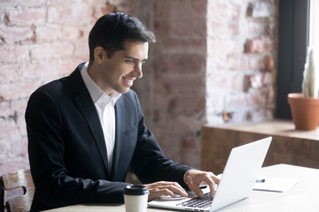 Smiling businessman or business owner working on computer in office at workplace. Concept of...