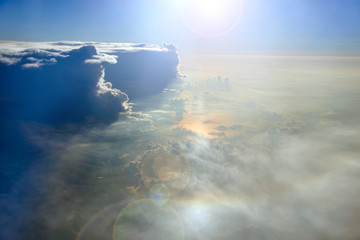 Wonderful view from window of plane in morning sun over clouds