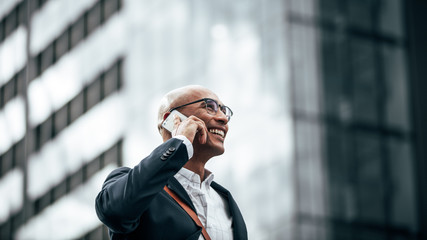 Business executive talking on mobile phone outdoors