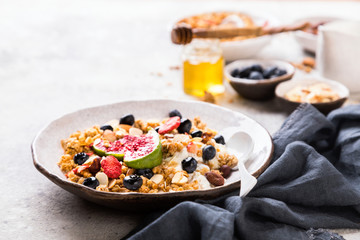 Muesli with Nuts Yogurt and fresh Figs Blueberry on the gray Background.Granola Healthy Breakfast. Sweet food Dessert. Snack  Dry Diet Nutrition Concept.Copy space for Text