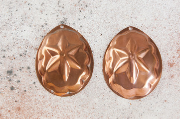 Vintage copper molds on a concrete background.