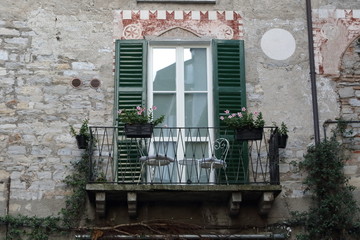 Fototapeta na wymiar balcone con vasi di fiori facciata casa antica