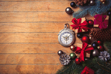 alarm clock with Christmas decoration around on wooden table. Above view in old color style