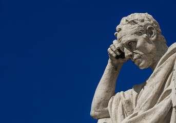 Man statue in the act of thinking against blue sky. Ancient Roman Julian the Jurist statue erected at the end of 19th century in front of the Old Palace of Justice in Rome (with copy space)