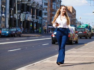 Young blonde business woman in blue jeans and white shirt