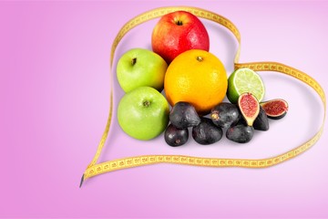 Fruits and in measure tape in diet on  background