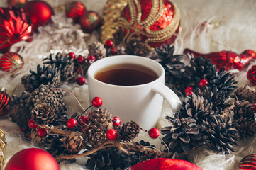 Hot tea and Christmas toys on a warm background of natural warm sheepskins. New Year 2019...