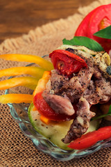 Roast meat with tomatoes on baked zucchini slices, close-up.