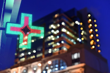 pharmacy sign in reflection of blurry background of business center