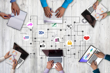 Business people from above working together in the office and using gadgets