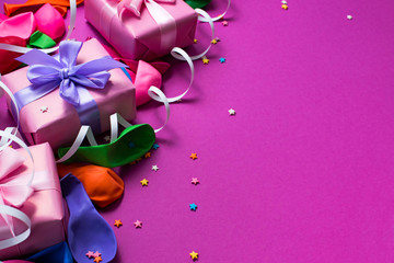 Festive background of purple material colorful balloons streamers confetti three boxes gift Top view flat lay copy space
