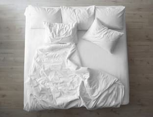 Comfortable bed with soft pillows indoors, top view