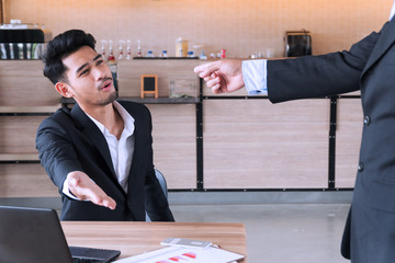 Young businessman argue unpleasant emotions with hand of boss or leader or colleague pointing finger to him after meeting in coffee shop. Concept business competition.
