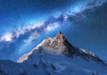 Milky Way above snowy mountains. Space. Fantastic view with snow covered rocks and starry sky at night in Nepal. Mountain ridge and sky with stars in Himalayas. Landscape with bright milky way. Galaxy - obrazy, fototapety, plakaty