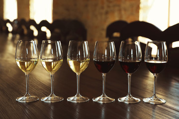 Glasses of white and red wines on wooden table