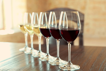 Glasses of white and red wines on wooden table