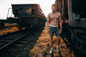 Sports guy in nature near the trains.Pumped guy.Sports guy