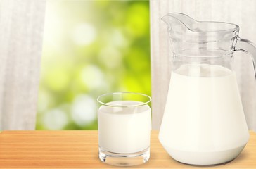 Glass of milk and jug on  white