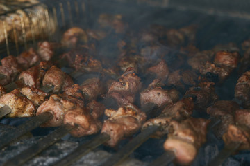 Roasted meat cooked at barbecue. Grilled kebab cooking on metal skewer. BBQ fresh beef meat chop slices. Traditional eastern dish, shish kebab. Grill on charcoal and flame, picnic, street food