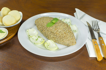 Raw quibe garnished with mint and onion.