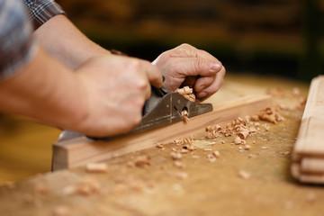 Carpenter working with planer on the workbench