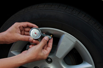 Hand holding pressure gauge for car.