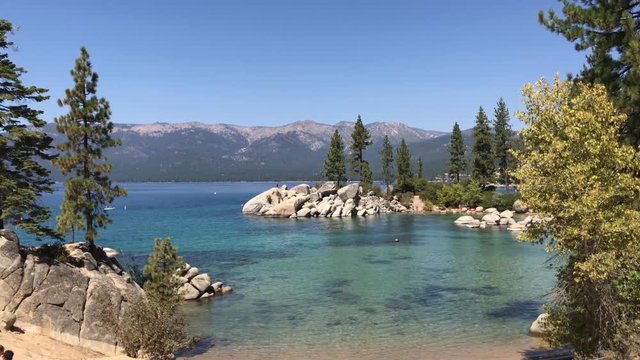 A wide picturesque establishing shot of Lake Tahoe, California on a sunny summer day.  	