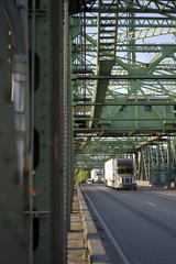 Big rigs semi truck convoy transporting commercial cargo on Columbia Interstate Bridge