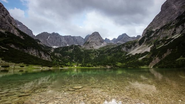 Time lapse of mountains clouds and sunrays refection in alpine lake Seebensee near Ehrwald Tirol Tyrol Austria Europe Alps landscape nature