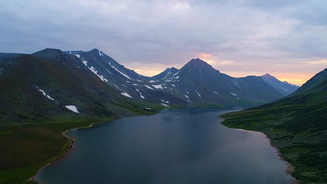 Cloudy sunset over the big lake Hadatayoganlor. Polar Ural, Russia (aerial video) 