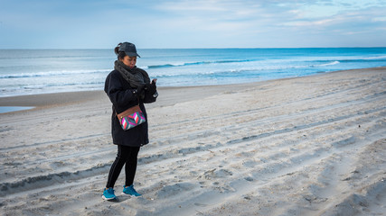 Woman on beach with cell phone © David