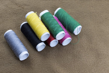 Several bobbins on a background of brown cloth