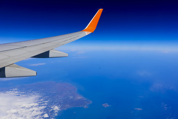 Fototapeta na wymiar airplane wing over the blue cloud sky