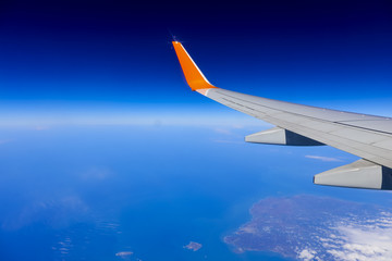 Fototapeta na wymiar airplane wing over the blue cloud sky