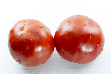 two tomatoes on a white table