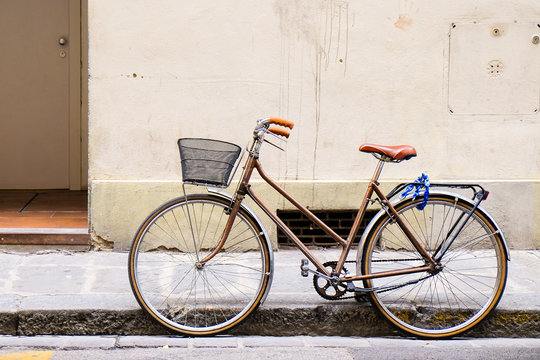 Old retro bicycle standing on a street in Florence, Italy by a wall