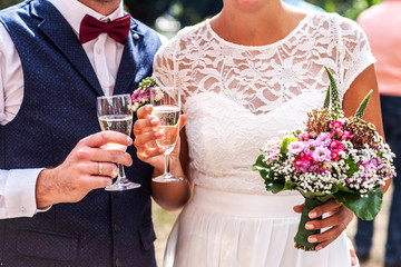 bride and groom holding beautifully wedding glasses with champaign sparkling wine toast